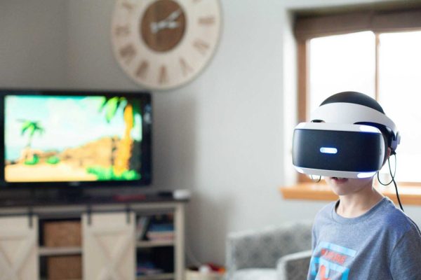 A boy wearing a virtual reality headset, enjoying an immersive gaming experience indoors.