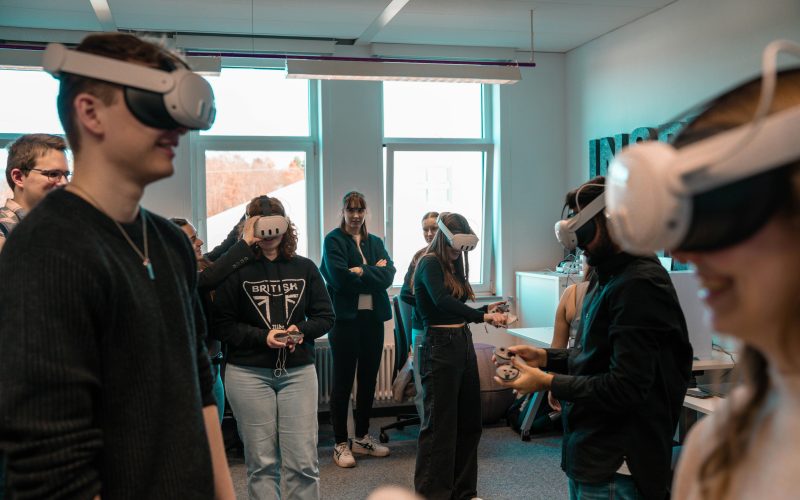 A group of diverse adults using VR headsets in an office setting.