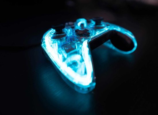 Illuminated gaming controller with blue lights on a dark background, perfect for gaming themes.
