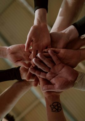 Group of people in a huddle showing unity and teamwork.