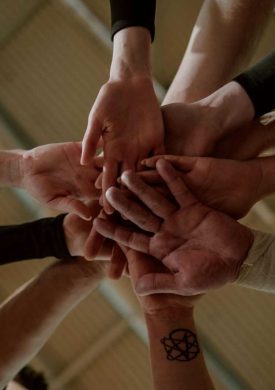 Group of people in a huddle showing unity and teamwork.